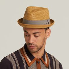 This unlined hat exudes effortless style and sophistication with its minimalist design and quality craftsmanship. Adorned with a 15mm square brown metal badge, it boasts an air of authenticity and refined detail. The grosgrain band adds a touch of elegance to the overall aesthetic, complementing the hat's clean lines. With a 1-inch skimpy turned-up brim, this hat offers a subtle yet stylish look, perfect for sunny days.  Its tear drop crown design adds a classic touch, enhancing its timeless app Modern Fedora With Short Brim For Everyday, Classic Solid Fedora For Spring, Classic Solid Color Boater Hat For Spring, Fitted Beige Fedora Hat, Beige Fitted Fedora Hat, Modern Fitted Fedora For Spring, Spring Modern Fitted Fedora, Modern Fedora With Adjustable Fit And Short Brim, Modern Adjustable Fedora With Short Brim