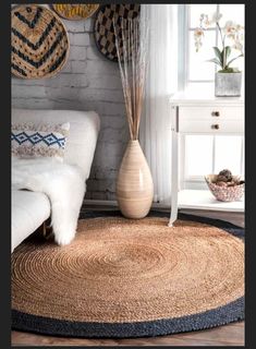 a living room with white furniture and baskets hanging on the wall above the rugs