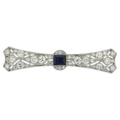 This is an Art Deco sapphire and diamond brooch from the luxury French jewellery designer LaCloche Frères. The brooch is crafted in platinum and the central sapphire is a mid to dark blue hue. The darker tone of the sapphire emphasises the bright white sparkle of the perfectly matched old cut diamonds. This brooch is as wearable today as it would have been 100 years ago. LaCloche is synonymous with some of the most exciting jewellery of the early 20th Century. The firm closed its doors in 1931, Formal Sapphire Diamond Brooch, Formal Sapphire Diamond Brooches, Elegant Sapphire Diamond Brooch, Elegant Sapphire Diamond Brooches, Art Deco Diamond Brooches With Gemstone, Diamond Gemstone Brooches In Art Deco Style, Classic Diamond Brooch With Gemstones, Classic Diamond Gemstone Brooches, Classic Evening Brooches With Diamond Accents