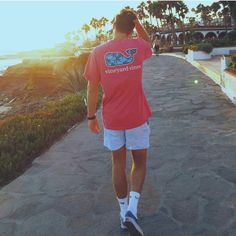 a man walking down a sidewalk next to the ocean