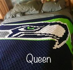 a crocheted blanket with the word queen written across it in white and green