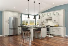 a large kitchen with white cabinets and wood floors