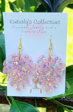 a pair of pink and yellow earrings on top of a card