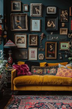 a living room filled with lots of framed pictures on the wall and yellow couches