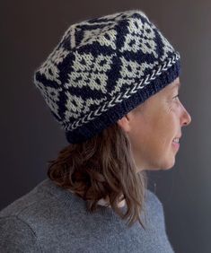 a woman wearing a blue and white knitted hat with diamond pattern on the brim