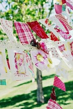 many colorful flags are hanging from a tree