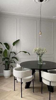 a dining room with white chairs and a black table