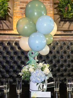 a table topped with lots of balloons and flowers