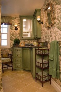 a bathroom with green cabinets and wall paper