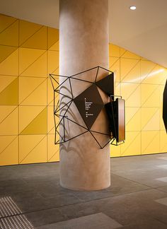 an abstract sculpture in the middle of a room with yellow and black tiles on the walls