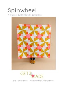 the cover of spinwheel quilt pattern is shown in orange and white, with an image of