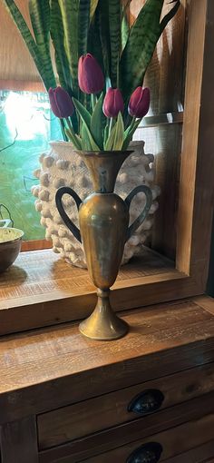 a vase filled with flowers sitting on top of a wooden table