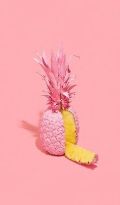 a pink and yellow pineapple sitting on top of a pink background with the peel cut off