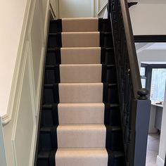 a staircase with carpeted steps leading up to the second floor