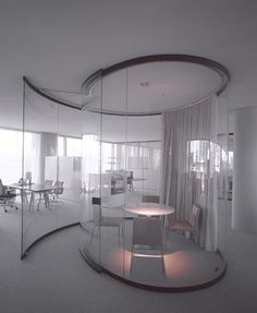 an office with glass walls and round table in the center, surrounded by chairs and desks