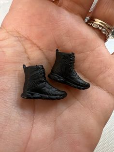 two tiny black shoes are sitting on someone's hand