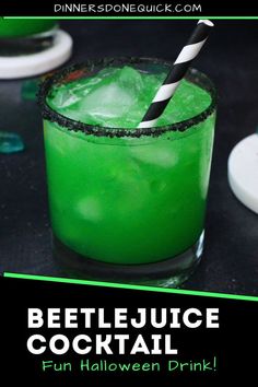 a green drink with a black and white striped straw in it