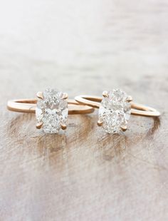 two engagement rings on top of each other with one diamond in the middle and another ring at the bottom