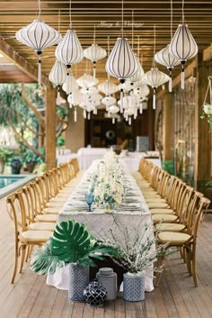 a long table is set up with hanging lanterns