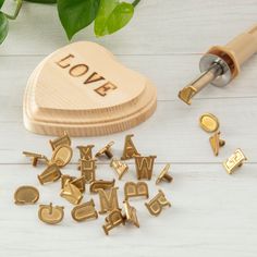 wooden letters and magnets are placed next to a heart shaped box with the word love on it