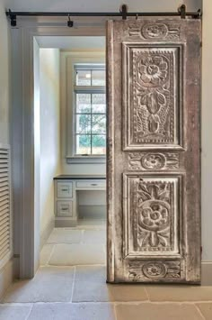 an old door is opened to reveal a room with white walls and tile flooring