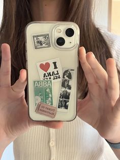 a woman holding up her phone case with pictures on it