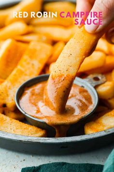 a person dipping sauce on french fries in a frying pan with the words red robin campfire sauce