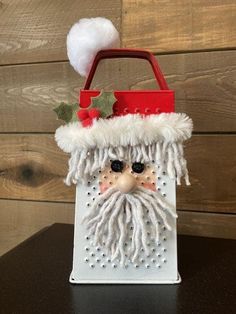 a white bag with a santa claus face on it and a red handle is sitting on a table