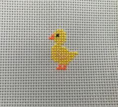 a small yellow ducky on a white background is depicted in the cross stitch pattern