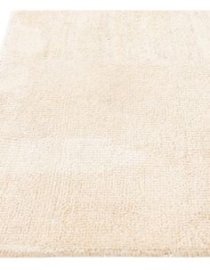 a large white rug on top of a wooden floor