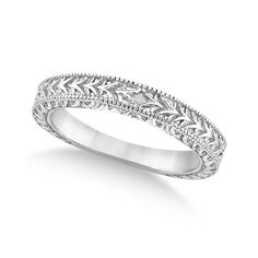 a white gold wedding ring with filigrees and leaves on the sides,