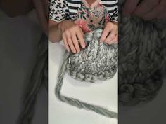 a woman is working with yarn on a table