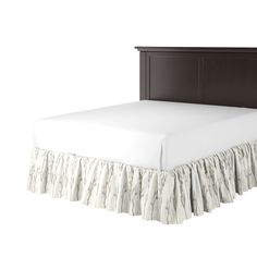 a bed with a white bedspread and a brown headboard on top of it