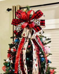 a decorated christmas tree with red, white and black bows