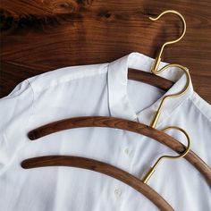 three wooden clothes hangers on a white shirt