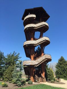 a tall wooden structure sitting on top of a lush green field