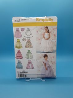 the sewing pattern for this girls'dress is in its package, and it has an attached