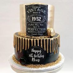 a black and gold birthday cake with an aged label on it