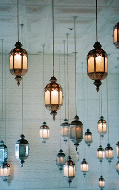 a bunch of lights hanging from the ceiling in a room with white walls and flooring