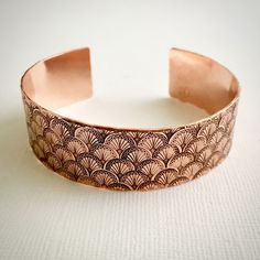 "This bracelet is formed from 16 gauge (1.3mm) pure copper that measures 3/4\" wide. It is 6\" long with a gap of a little over 1\" and will fit most women's wrists. It can be gently adjusted by bending slightly to make it easy to put on and take off and comfortable to wear. The bracelet is hand stamped with an Art Deco fan motif and sealed to protect from tarnish. If you think you may need a different size just leave a note at checkout and I'll contact you about sizing. The bracelet will arrive Handmade Rose Gold Copper Cuff Bracelet, Adjustable Etched Bronze Cuff Bracelet, Adjustable Bronze Etched Cuff Bracelet, Rose Gold Copper Bangle Cuff Bracelet, Rose Gold Copper Cuff Bangle, Engraved Bronze Copper Bracelets, Copper Etched Bracelets As A Gift, Bronze Copper Cuff Jewelry, Gold Cuff Bangle Made Of Copper