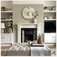 a living room filled with furniture and a fire place in front of a flat screen tv