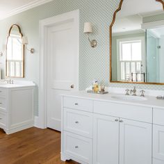 a large bathroom with two sinks and mirrors