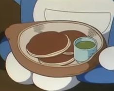 a cartoon character holding a plate with pancakes on it and a cup of green liquid