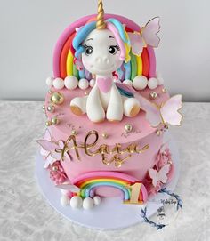 a birthday cake with a unicorn on top