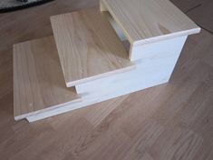 three pieces of wood sitting on top of a wooden floor next to a cat bed