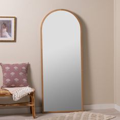 a mirror sitting on top of a wooden floor next to a bench