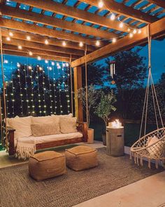 an outdoor living room with lights strung from the ceiling