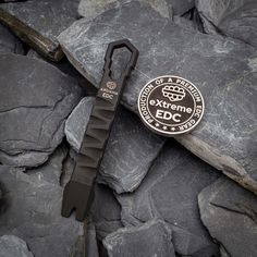 an extreme edc knife laying on top of some rocks with the logo of a marine