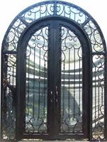 an ornate iron door with glass panels