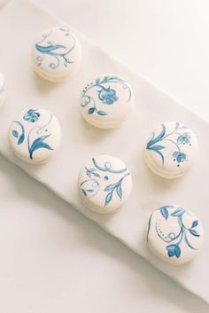 six blue and white decorated cookies sitting on top of a plate next to each other